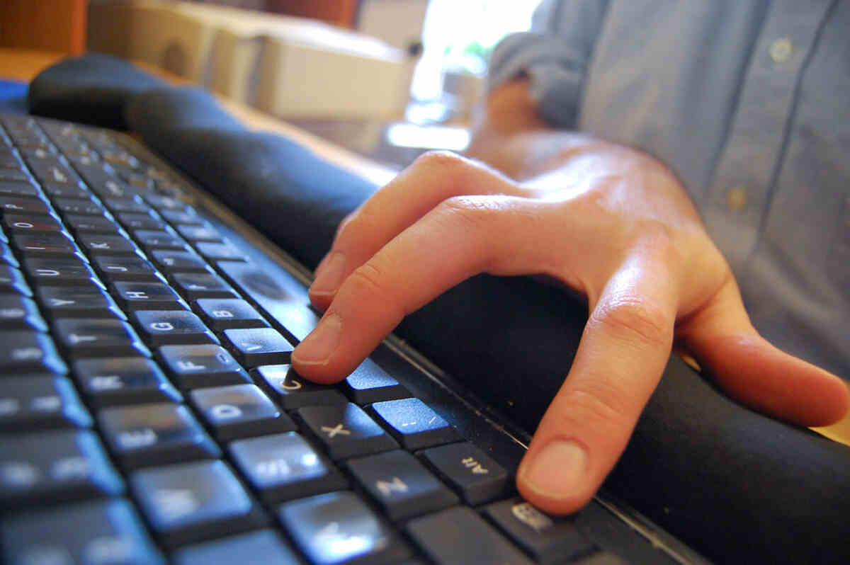 Person's hand pressing keys on a black laptop keyboard demonstrating how to copy and paste on a laptop using keyboard shortcuts