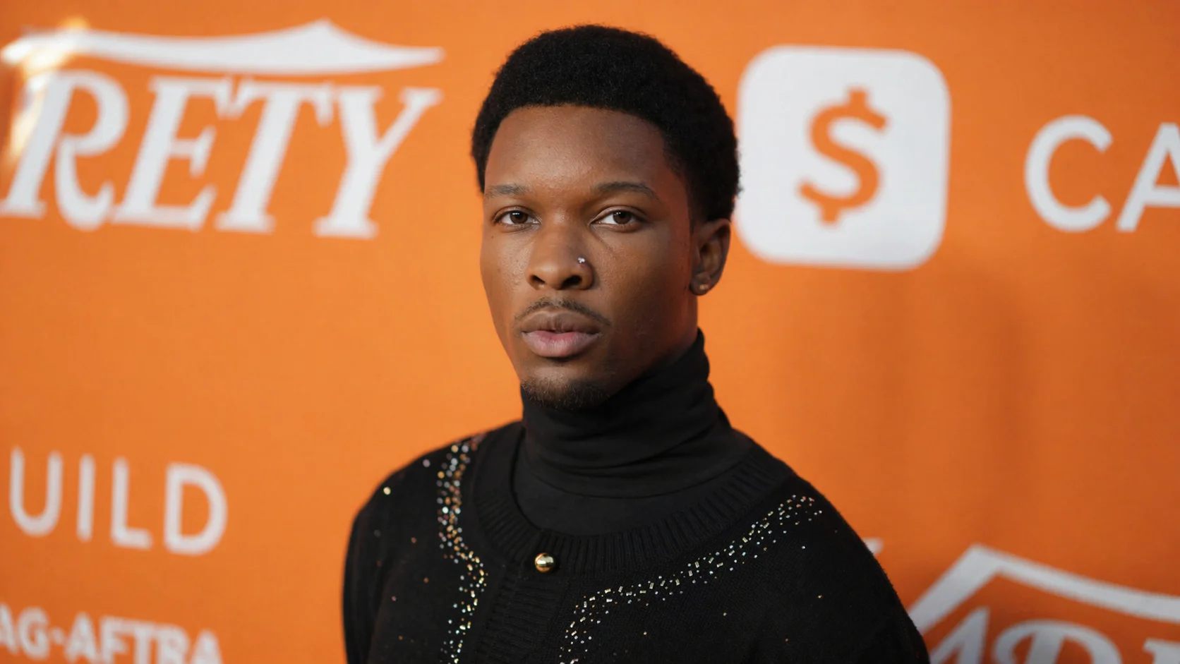 Artist d4vd (David Anthony Burke) in a moody, low-light portrait, reflecting the indie-pop and lo-fi aesthetic of his debut album Withered.