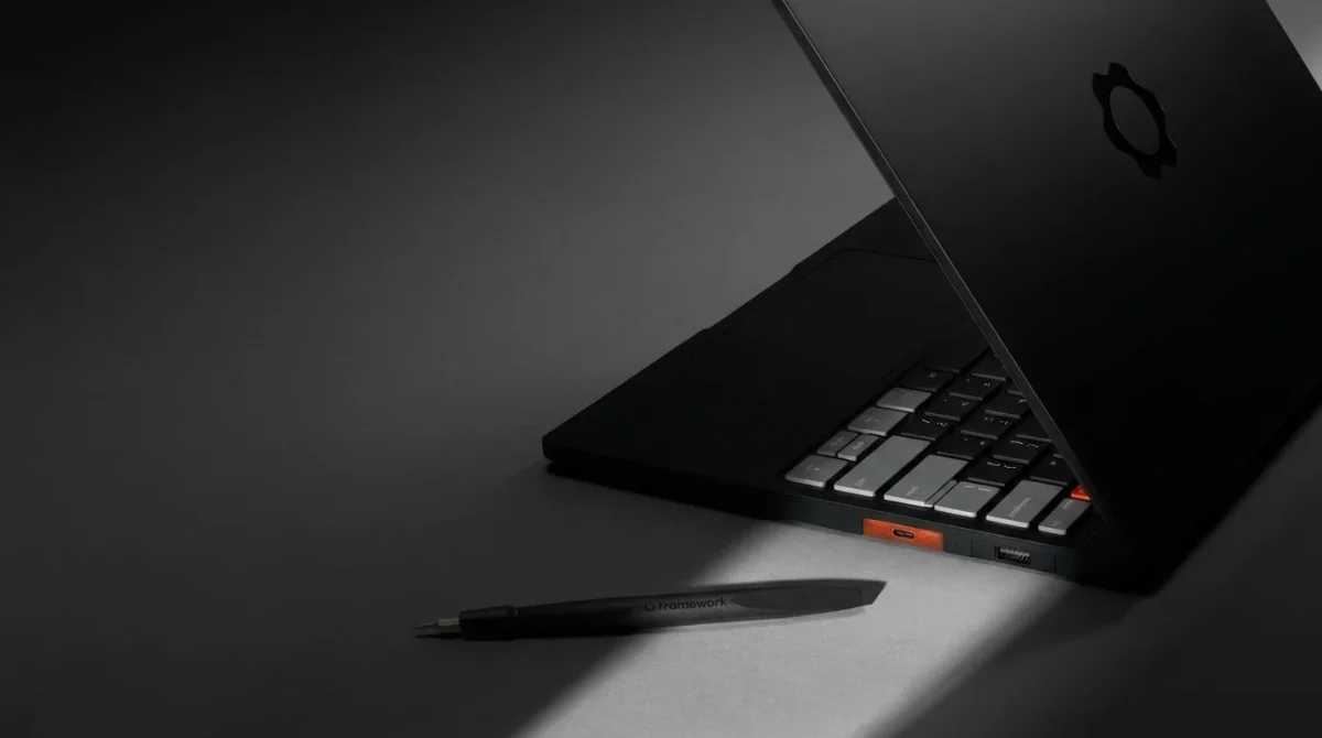 A side-profile view of the new Framework Laptop 13 Pro in the 2026 "Graphite" colorway. The image highlights the ultra-slim 15.85mm CNC-machined aluminum chassis and the premium 13.5-inch 2.8K touchscreen display. Four expansion card slots are visible along the side, emphasizing the laptop's modular design.
