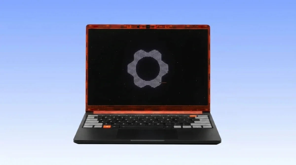 A top-down view of the new Framework Laptop 13 Pro (2026) featuring a custom orange translucent bezel. The image showcases the sleek CNC aluminum chassis in Graphite and the modular 13.5-inch 2.8K touchscreen display. The orange bezel highlights the brand's focus on personalization and repairability.