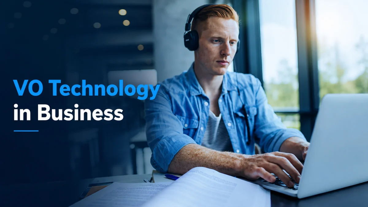 A professional man wearing headphones while working on a laptop in an office, illustrating the use of VO Technology in business environments.