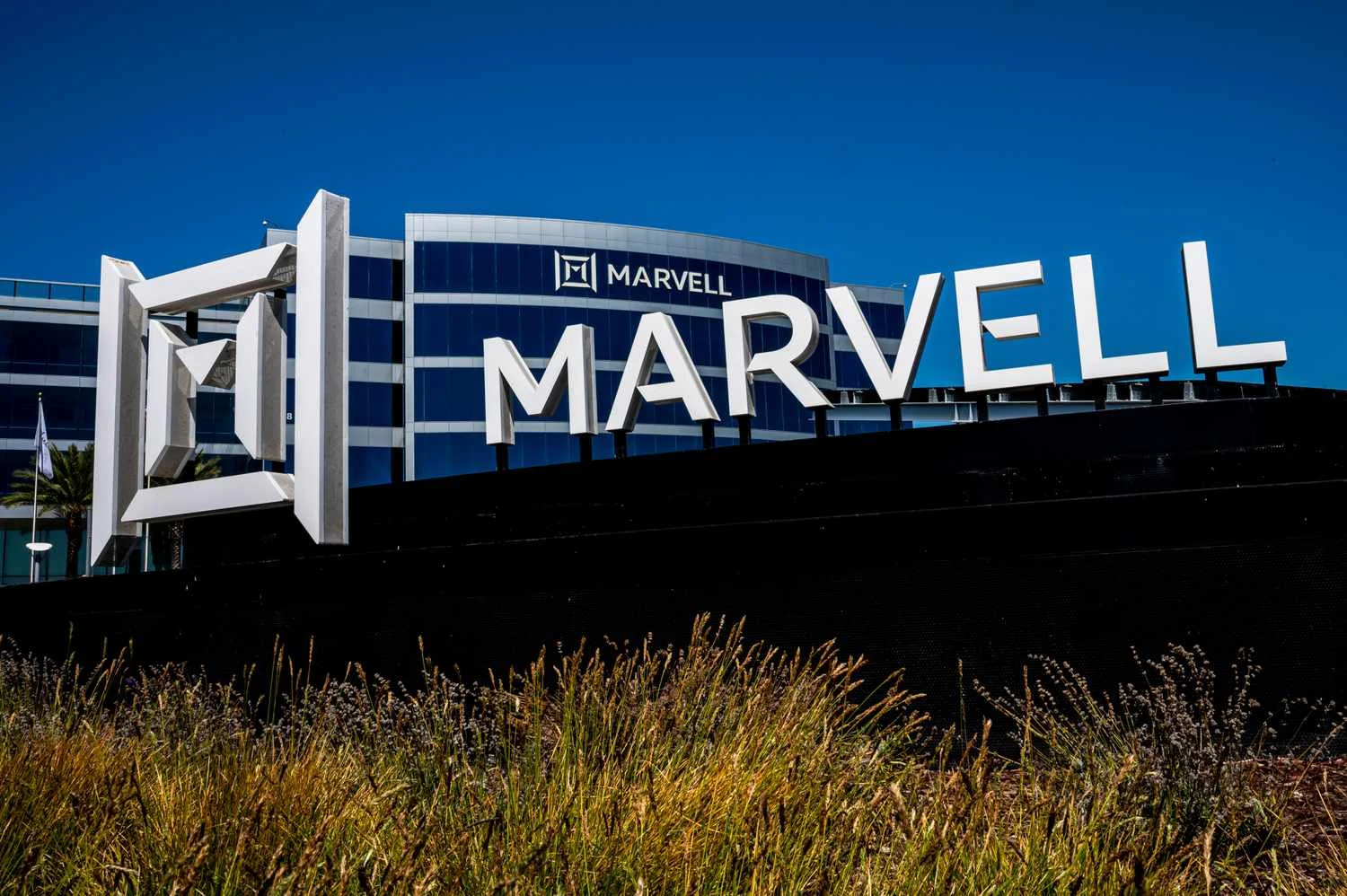 Large white Marvell signage and geometric corporate logo standing outside the modern glass headquarters building, representing marvell stock infrastructure.